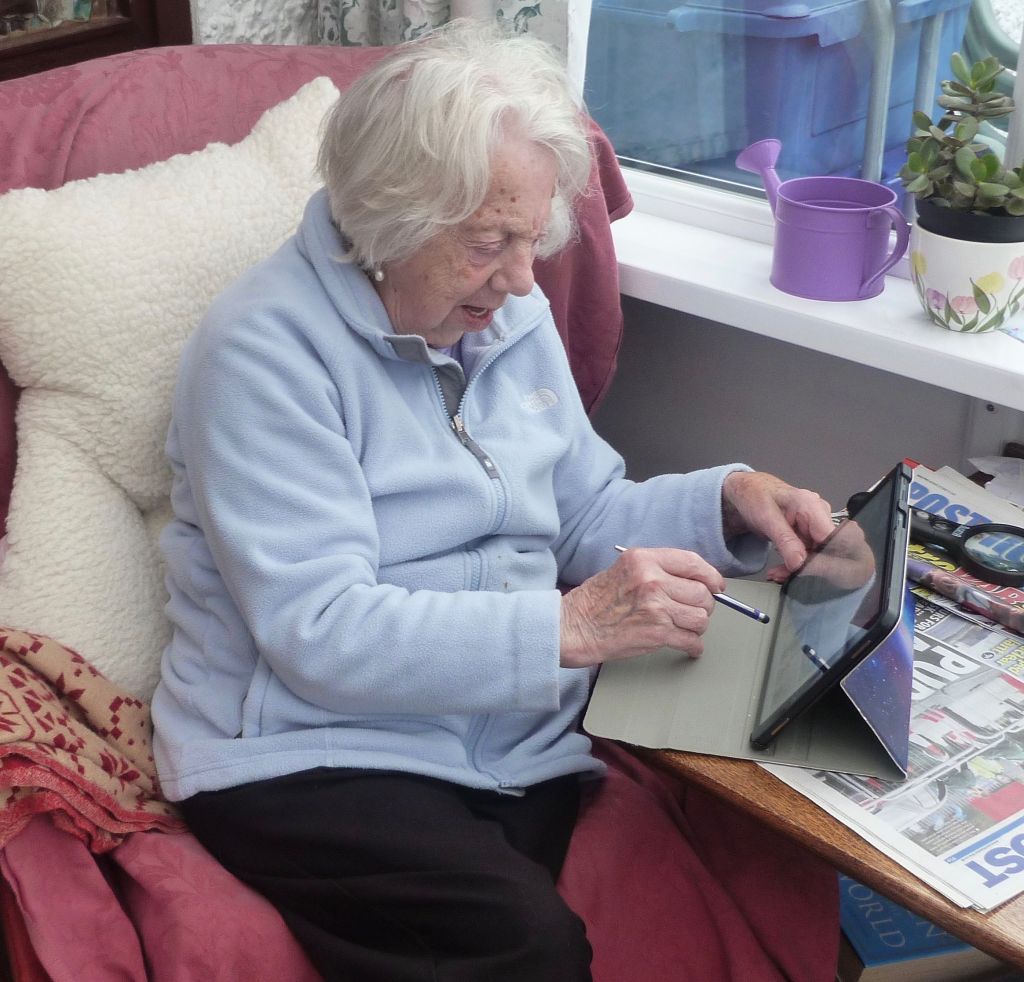 elderly lady using an ipad with a stylus